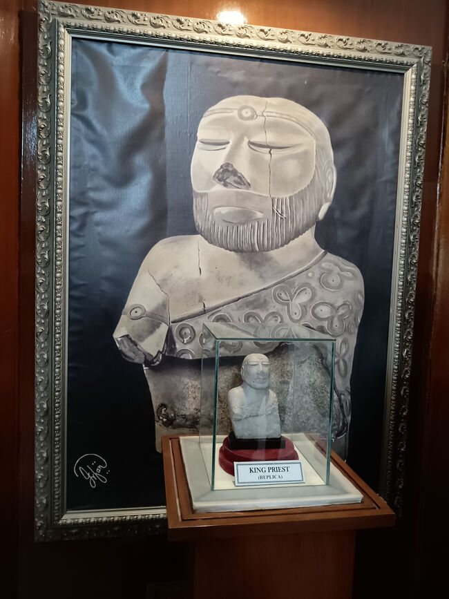 キング・プリーストの肖像画と胸像(レプリカ)。<br />胸像は、モヘンジョダロ遺跡から発見されたもので、高さ17.5cmで元は赤色の顔料で塗られた三つ葉模様のローブを羽織っており、インダス文明の芸術性の高さを示しています。<br />