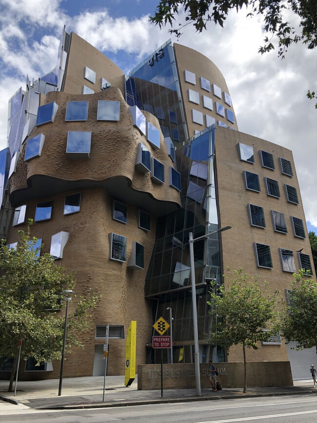 その正体はシドニー工科大学(UTS)敷地内に有る Dr Chau Chak Wing Buildingでその外観が風変わりでシドニーでも名建築の1つではないでしょうか？<br /><br />茶色の煉瓦ブロックの外観は奇抜過ぎて片面はガラス張りの透ける様なモダン建築、反対側はバルセロナのガウディ建築の様にくねくねした曲線を多用した32万個を使用した煉瓦ブロックの外壁にガラスボックスの様な窓を不規則に付けています。<br /><br />