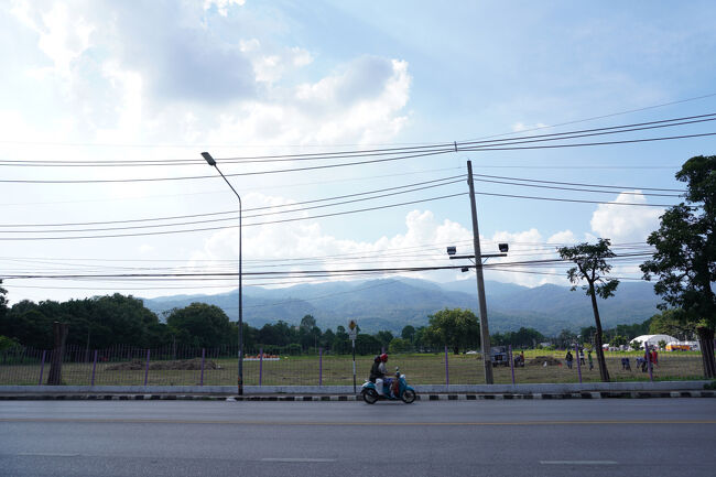 チェンマイ大学沿いを歩いています。<br />山が見える街っていいなぁ。<br /><br />ここの道路、車通りは多いのですが人が全然歩いていません。<br />不安だけど、歩道があるから堂々と歩くよ。