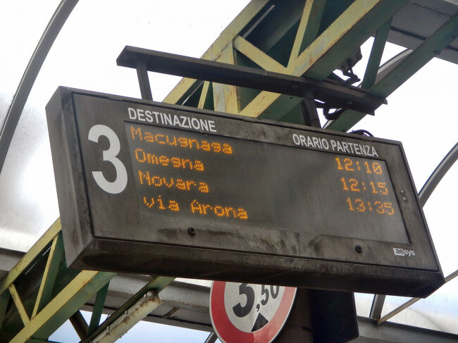 3番のプラットフォームの電光掲示板。一番上のマクニャーガ行きに乗る。<br />マルペンサ空港からの｢Alibus｣以外のCOMAZZI社のバスは予約ができない。<br />運賃はマクニャーガ村のスタッファ集落まで1人5ユーロ。運転手に現金で支払う方法以外にチケットを購入することはできず、手数料を1ユーロ追加して取られるのがちょっと悔しい。1時間半乗車して合計6ユーロなので文句も言えないか。(現地の人はカード大の厚紙でできた回数券のようなものを使っているが、入手方法はわからない。)<br />バスは時刻表どおりに出発し、スタッファの広場前のバス停に13時30分過ぎに到着した。