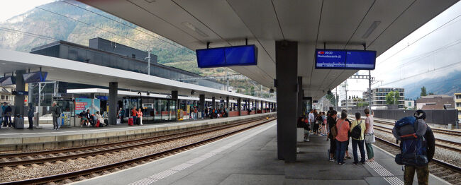 計画ではブリーク駅でドモドッソラ行き列車に乗り換えるつもりだったのだが車内でインターネットの時刻表を見ている時に、乗車予定の列車はブリーク始発ではなくチューリッヒ中央駅始発だということに気がついた。そしてヴィスプ駅で下車すれば同じホームでドモドッソラ行き列車に乗り換えられることにも気がついた。（ブリーク駅だと、地下道を通ってホームを移動しなければならない。）<br />ということで9時15分にヴィスプ駅で下車。写真は9時17分、ヴィスプ駅でドモドッソラ行き列車を待つ乗客。けっこう皆さん裏技をご存知のようだ。