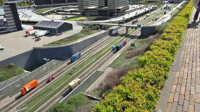 空港のそばを走る多車線の高速道路がリアルに再現されており、トラックや乗用車が行き交う様子から、交通の多さと空港の規模が伝わってきます。