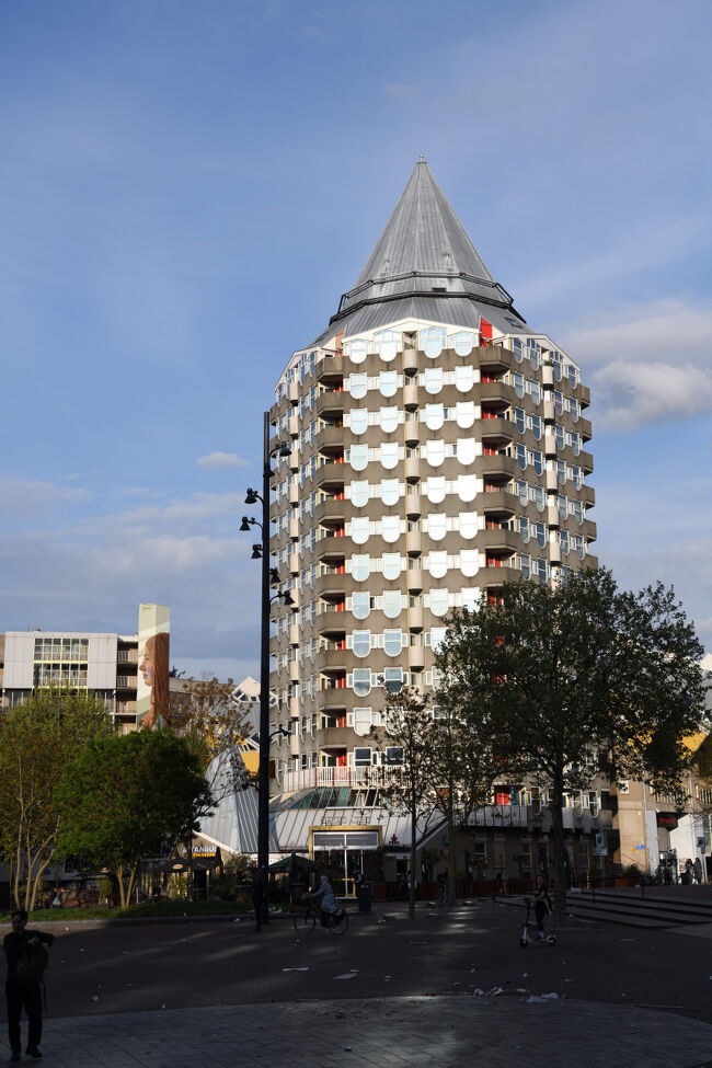 マルクトハルを出ると、まだ空は明るく、広場の向こうに特徴的な形のBlaaktoren（通称「鉛筆ビル」）が見えました。<br />この建物は団地・共同住宅として使われていて、ロッテルダムの街並みにユニークなアクセントを加えています。