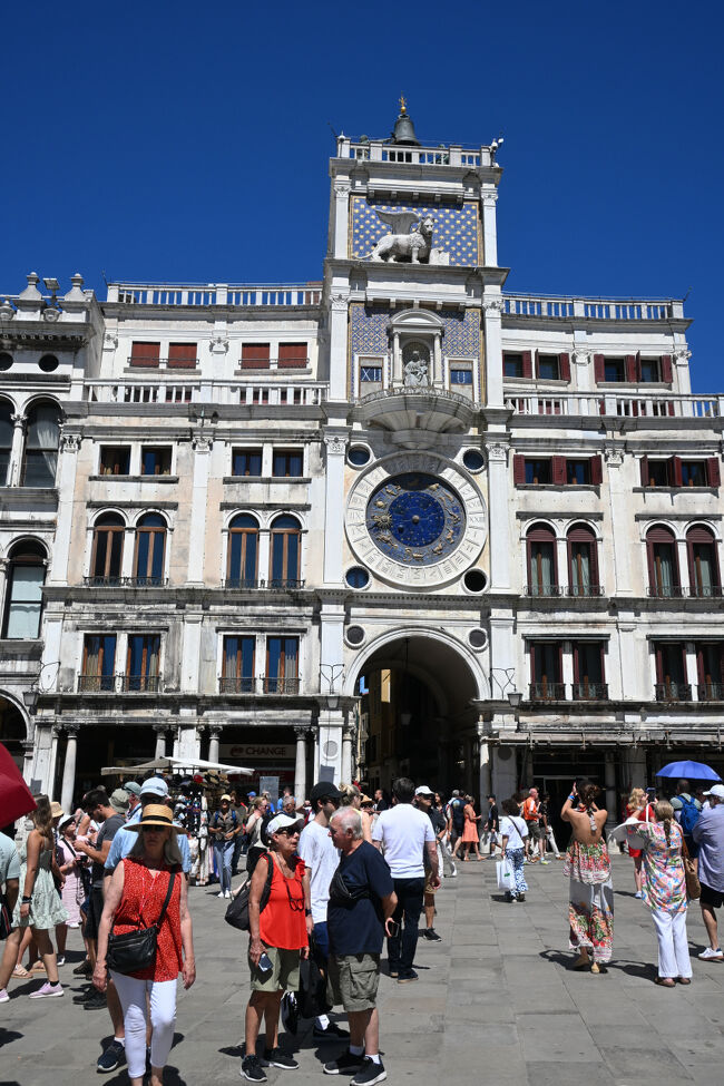 広場の隅にある時計塔。時刻を示す周りの数字は1から24まであるので、24時間で1周する。また、内側には十二宮のシンボルがあり、時期による月の満ち欠けや太陽の位置も示していたという多機能型。塔の上部に飾られた翼をもつライオン像はベネチアのシンボルである。