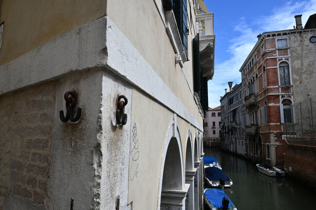 途中、ベネチアのラッキーアイテムの一つ「ソトポルテゴ・デル・トラゲットの金具」を発見。2個の金具を触って揺らせば幸運が訪れるという。中世の時代、この金具には死罪になった罪人の遺体が見せしめのために吊るされていたともあり、どう考えても元・特級呪物である。なぜラッキーアイテムになったかは諸説あるようだが、「私たちはまだ生きてるよね。イェーイ！」というノリで触る人が出はじめ、「生きてるだけで丸儲け」的な発想に転じてラッキーアイテム化したとのこと。