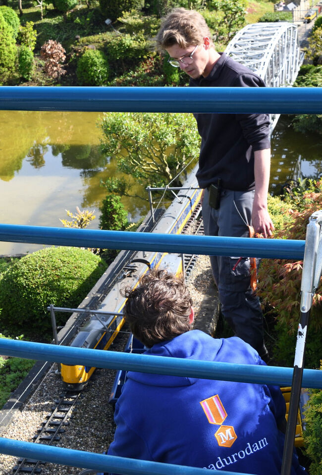 マドローダムのスタッフが列車の調整をしている様子で、橋や水辺のある風景の中に、丁寧に手入れされた模型の世界が広がっていました。