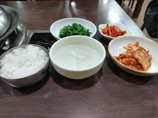 鍋に火が点けられて　さっそくおかずとご飯が運ばれてきました。<br />ブデチゲができたら店員さんが教えてくれます。