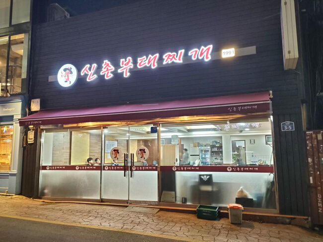 夕方、最寄りの堂山駅から地下鉄２号線で新村駅まで移動。３つ目の駅なのですぐ近くです。<br />ここはブデチゲを一人で食べられるお店です。<br /><br />https://maps.app.goo.gl/aXuopzeAokF2NH889