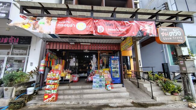 トランバスターミナルからGrabで、トラン駅前至近の「チョムトラン」という宿に移動。<br />トランではここに2泊した。1階にミニ商店が入っていた。<br />2日後の夕方発の寝台列車に乗る予定だったので、レイトチェックアウトを交渉。<br />曰く、「午後2時までなら無料でOK。午後4時（寝台列車の出発1時間前）までなら300B、現金のみ」と言われた。<br /><br />迷ったが、直前にシャワー＆ジャージに着替えしたかったので、300Bで妥結。