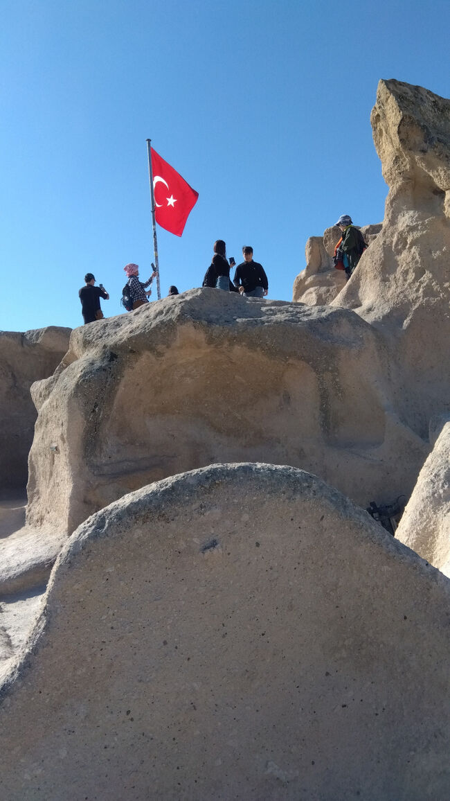 ウチヒサール城の頂上には国旗がはためきます。城内に入るには一人320トルコリラ必要です。