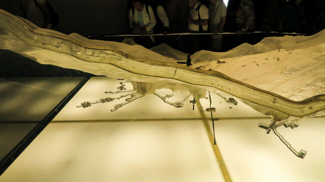 王家の谷ビジターセンターに来ました。ここで入場券を購入します。<br />入場券はツタンカーメンの墓、ラムセス６世の入場券とそれら以外の墓に３箇所入ることができる入場券があります。<br />ガイドと相談し、今日は大変混雑しているので、長蛇の列ができているであろうツタンカーメンの墓は諦めて、それ以外で比較的状態の良い墓を見学することにしました。（このツアーはツタンカーメンの墓を見学するという行程にはなっていません。）<br />ガイドも長時間待つのは苦痛なのかも。<br />これは、王家の谷のジオラマです。反対側から撮っています。ジオラマでは、それぞれの墓の部屋の配置まで表現されています。<br />