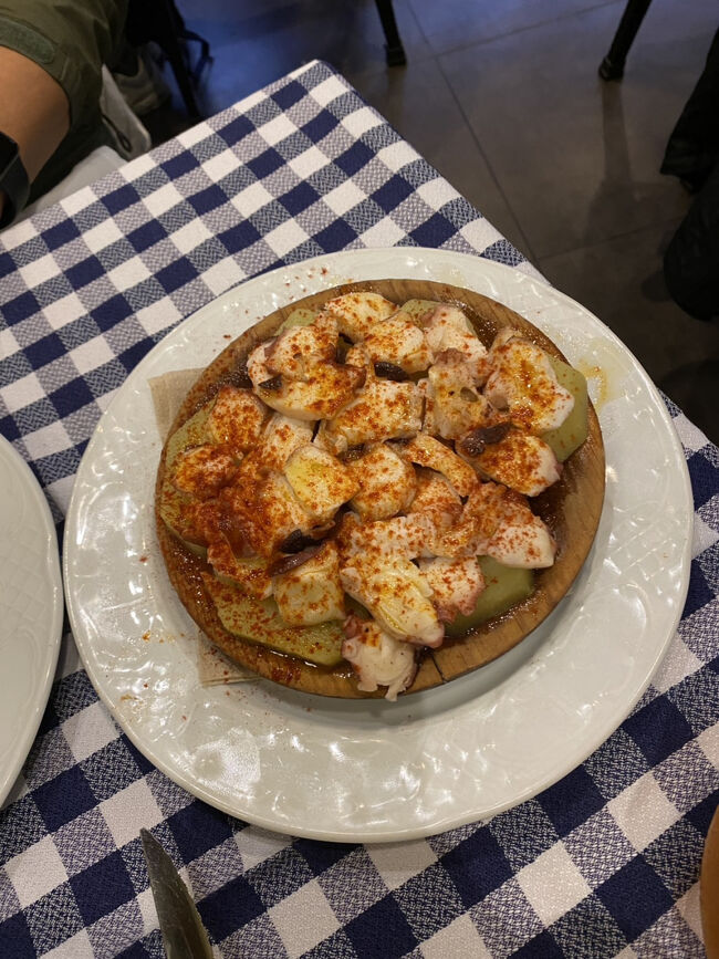 タコのガリシア風<br />このお料理はスペイン北西部ガリシア地方の伝統料理です。<br />柔らかく茹でたタコとジャガイモを丸い木皿に盛り付け、たっぷりのオリーブオイル、パプリカパウダー、粗塩をかけてシンプルなお料理です。<br />26.8ユーロ