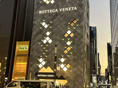 銀座って・・・こんな街・BOTTEGA VENETA 銀座フラッグシップ店
2018年12月8日にオープンした、アジア最大級の広さを誇るボッテガ・ヴェネタの旗艦店です。内部は、日本の伝統的な要素を取り入れたデザインが特徴です。 晴海通りから入ると、外と内をつなぐ「土間」をイメージした空間があり、鉄平石のフロアからオーク材のフローリングへと変化します。 また、「折り紙」をイメージした窓や壁面の幾何学的な形状、左官職人が漆喰を塗った壁面など、日本の職人技が随所に光る洗練された空間となっています。 来店客を非日常へと誘い、心を込めてもてなすという日本的な精神が建築全体に表現されています。