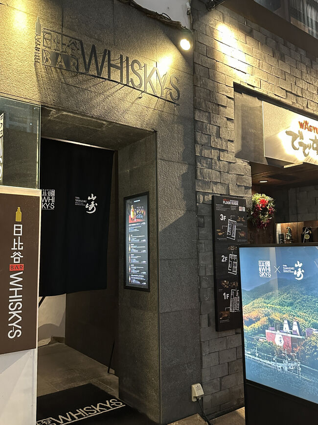 日比谷BAR WHISKY-S・エントランス<br />ここが【期間限定・完全予約制】の特別イベント「THE YAMAZAKI EXPERIENCE IN GINZA」のバーです。外部サイン看板は、山崎蒸留所の写真です。<br /><br />銀座には多くの素晴らしいバーがあり、日本のバー文化は世界的に高く評価されています。特に銀座は、オーセンティックバーと呼ばれる格式高いバーが多いエリアです。バーテンダーの皆さんは、一杯一杯丁寧にカクテルを作り、その所作の美しさや氷・グラスの扱い方など、動きに美学が宿っているのが特徴です。<br />