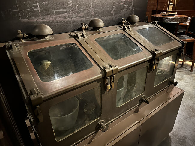 日比谷BAR WHISKY-S・展示品<br />これは、実際に山崎蒸留所で使われていた「スピリットセーフ（Spirit　Ssfe）」と思われます。このスピリットセーフは、蒸留されたばかりのウイスキーの原酒（ニューポット）の品質を管理するための重要な装置です。この中を通り、蒸留所の担当者がガラス歌詞に液体の透明度や流れを確認します。マニアックな装置と言えます。