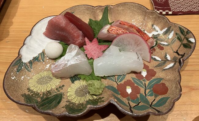 お刺身<br /><br />本鮪の赤身と中トロ、金目鯛の炙り、平目、イカ<br /><br />器の植物の名前言えたらサービスしますと<br />大将が言うので、答えたら当たってて<br />驚かれました、左手前の菊みたいな花が<br />難しいようです<br /><br />年の功ですか<br />