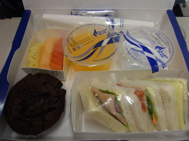 中身はこんな感じ、サンドウィッチとマフィン、フルーツ、オレンジジュースでした。