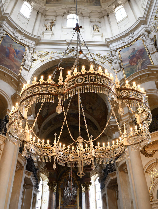 聖ミクラーシュ教会の中央に吊るされたシャンデリア。<br /><br />金色の装飾と灯りが空間を照らしていました。