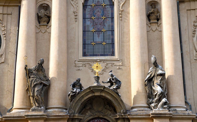 聖ミクラーシュ教会の正面中央。<br /><br />ステンドグラスの下に、金色の輝きを囲む彫像が並んでいました。