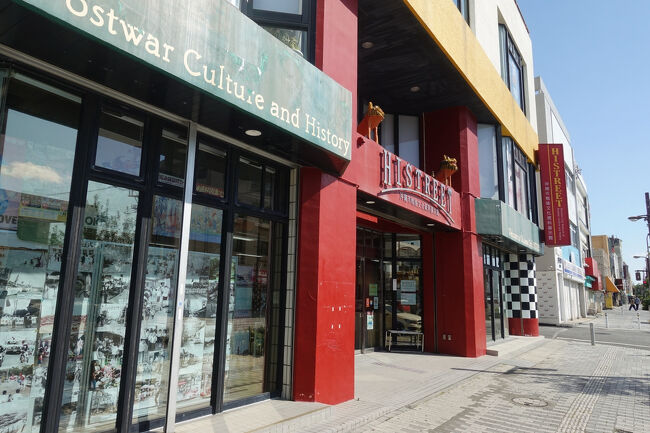 　そんな中に堂々と、沖縄市戦後文化資料館「ヒストリート」が建ちます。米軍の影響を受けつつ歩んできた、沖縄市の戦後史を学べる公営の資料館です。入場無料。<br />　展示は1970年のコザ暴動をはじめ、よく知らなかったことばかり。蓄積された怒りに、多くの米兵の車を焼き払いつつも、人命が奪われていないことは「命どぅ宝」の証でもあると思います。