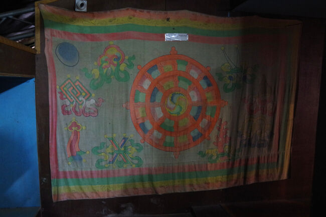 本堂の中の壁画は、グル・リンポチェの姿がたくさん描かれています。仏像もリンポチェの八変化。３階の奥には最近亡くなった高僧の墓であるストゥーパが置かれていました。これはシッキム王国の旗です。案内をしてくれている僧が、撮影を許可してくれました。<br />