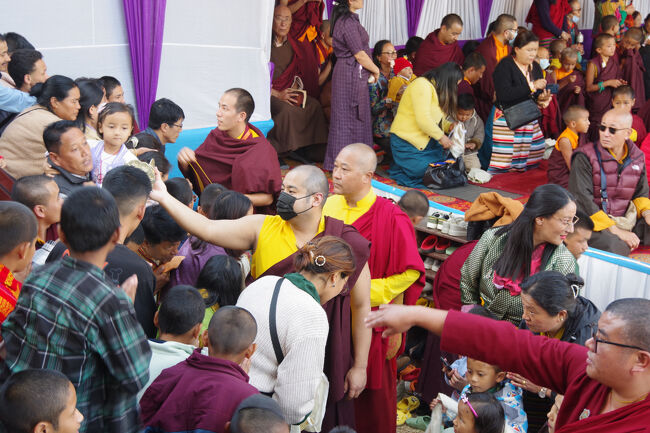 高僧が、仏具を額に当てて、祝福しています。