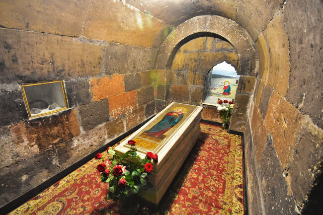 教会の中に地下に降りることができる階段がある<br />いわゆるクリプト（crypt, 地下聖堂）、フリプシメが眠る棺がある。<br /><br />この教会は作りが面白く、このクリプトは正面のメインとなるイコンのあるアプス（apse, 後陣=今回で言う半円状に凹んだ部分）の真下かやや後方の地下にあった。<br />中央がドームまではスタンダードだが、実はギリシャ十字形式の建築ではなく、四方がアプスで構成された四アプス形式であり、さらにその間のスキンチ（squinch）が入口になっている。<br />要は0°,90°,180°,270°がアプス、45°,135°,225°,315°が斜め方向の入口で、<br />正面側のスキンチがクリプトへの入口になっているのだ。<br />超簡単に言うと、90°ずつの4つ部屋があるのに加えて、45°からの4つにも部屋があるということ。<br />航空写真や外観を見ても四角柱に見えるのもそのためだ。